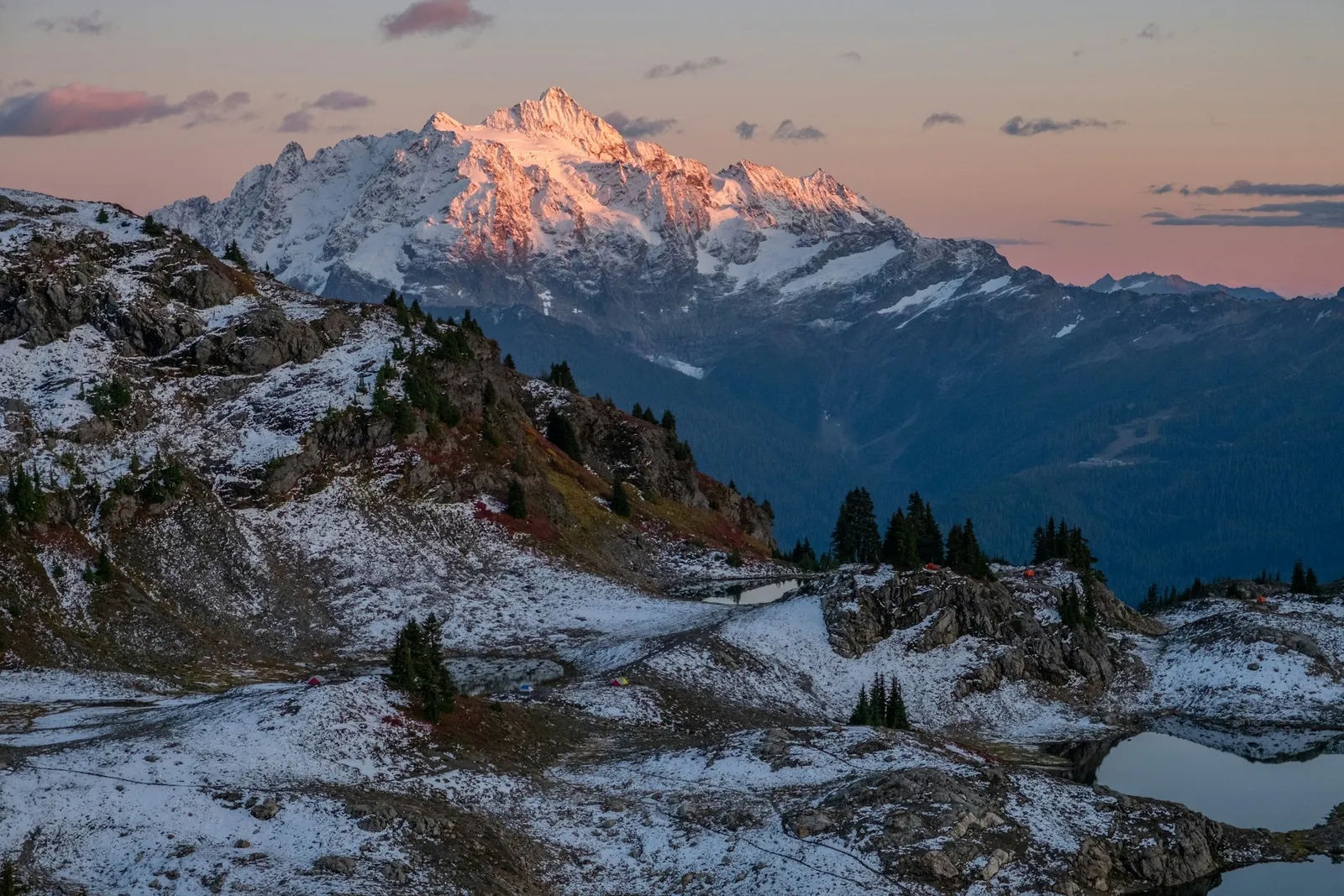 Mt. Shuksan at sunset above snow-dusted alpine meadows and a small lake